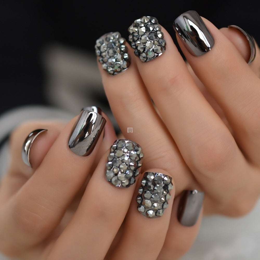 Metal false nails with square shape featuring shiny chrome and rhinestone embellishments on medium-length nails